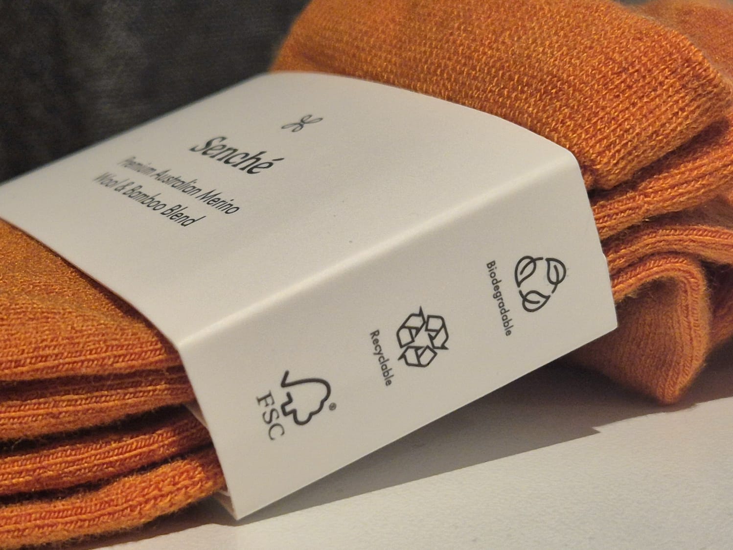 Orange socks with a white label on a light background
